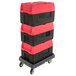 A stack of three red and black Metro Mightylite BigBoy food pan carriers on a dolly.