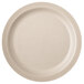 A close-up of a Carlisle beige polycarbonate plate with a white rim.