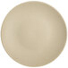 A close up of a Tuxton Zion matte beige coupe china plate.