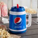A blue and white plastic 32 oz. Pepsi Mini Tanker with a spout and straw filled with a beverage next to a bag of popcorn.
