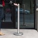 A person standing next to a Lavex stainless steel smoker pole.
