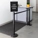 A black Lancaster Table & Seating sign that says "Line Forms Here" in a clear cover.