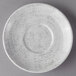 A white Schonwald porcelain saucer with a gray rim on a gray surface.