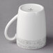 A white Schonwald mug with a grey surface and handle.