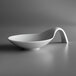 A close-up of a Schonwald white porcelain spoon-shaped bowl with a curved handle.