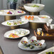 A Schonwald bone white porcelain platter with food on a table.