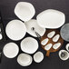 A group of Schonwald bone white oval coupe platters on a wood surface.