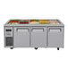 A Turbo Air stainless steel refrigerated buffet display table with three trays of food.