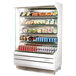 A white Turbo Air refrigerated display case with food and drinks on shelves.