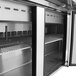 A Turbo Air stainless steel refrigerated sandwich prep table with 3 doors open.