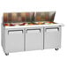 A Turbo Air stainless steel refrigerated sandwich prep table with food containers in it.