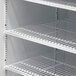 A white Turbo Air refrigerated merchandiser with shelves.