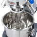 A Vollrath 20 Qt. commercial stand mixer with a wire whisk inside.