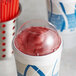 A frozen yogurt in a Dart clear dome lid with a red and white swirl on top.
