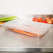 A Carlisle clear polycarbonate food pan with vegetables in it on a counter.