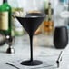 A black Stolzle martini glass with a drink in it.