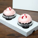 A white Baker's Mark reversible cupcake insert holding two cupcakes in a white box.