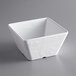An American Metalcraft white square melamine bowl on a gray surface.