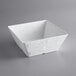 An American Metalcraft white square melamine bowl on a gray background.