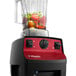 A Vitamix Vita-Prep 3 blender with a 64 oz. container filled with vegetables.
