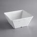 An American Metalcraft white faux slate square melamine serving bowl on a gray surface.