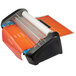 A black and orange Swingline GBC Pinnacle laminator with a roll of paper.