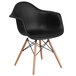 A Flash Furniture black plastic chair with wood legs.