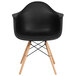 A black Flash Furniture plastic chair with wood legs.
