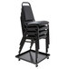 A black steel Alera Stacking Chair Dolly holding a stack of black chairs.