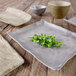 An Elite Global Solutions rectangular melamine tray in sandstone color with a plant on it.