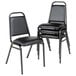 A stack of Alera black vinyl padded steel banquet chairs.