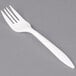 A close-up of a Dart white plastic fork.