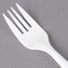 A close-up of a white Dart plastic fork.