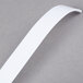 A white polystyrene disposable ladle with a long handle.