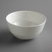 A Schonwald bone white porcelain bowl with a white rim on a gray surface.