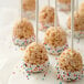 A Wilton brown silicone dessert mold with rice krispie treats on sticks with sprinkles.