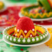 A Wilton brown silicone 8 compartment cake pop mold filled with sombrero-shaped cake pops on a plate.