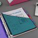 A binder with Avery 8-tab plastic dividers in blue and white with a calculator and a blue and green planner.