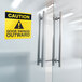 Avery Surface Safe square label with yellow caution sign on a glass door.