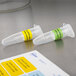 Two small plastic test tubes with green Avery labels.