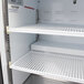 A white Turbo Air countertop display refrigerator with shelves and an open swing door.