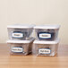 A group of clear plastic containers with Avery arched white and blue labels on them.