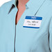 A woman wearing a blue and white Avery name tag that says "Hello Mr. Tiffer"