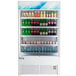 An Avantco white refrigerated air curtain display full of soda bottles.