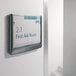 A Durable gray interior wall click sign holder with a sign on a wall.