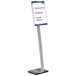 A Durable metal sign stand with a long rectangular black top and a sign with blue text in it.
