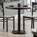 A Lancaster Table & Seating counter height table with two chairs.