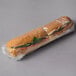 Clear plastic wrap around a sandwich.