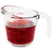 An Anchor Hocking clear glass measuring cup with red liquid inside.