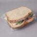 A turkey and cheese sandwich wrapped in LK Packaging clear plastic.